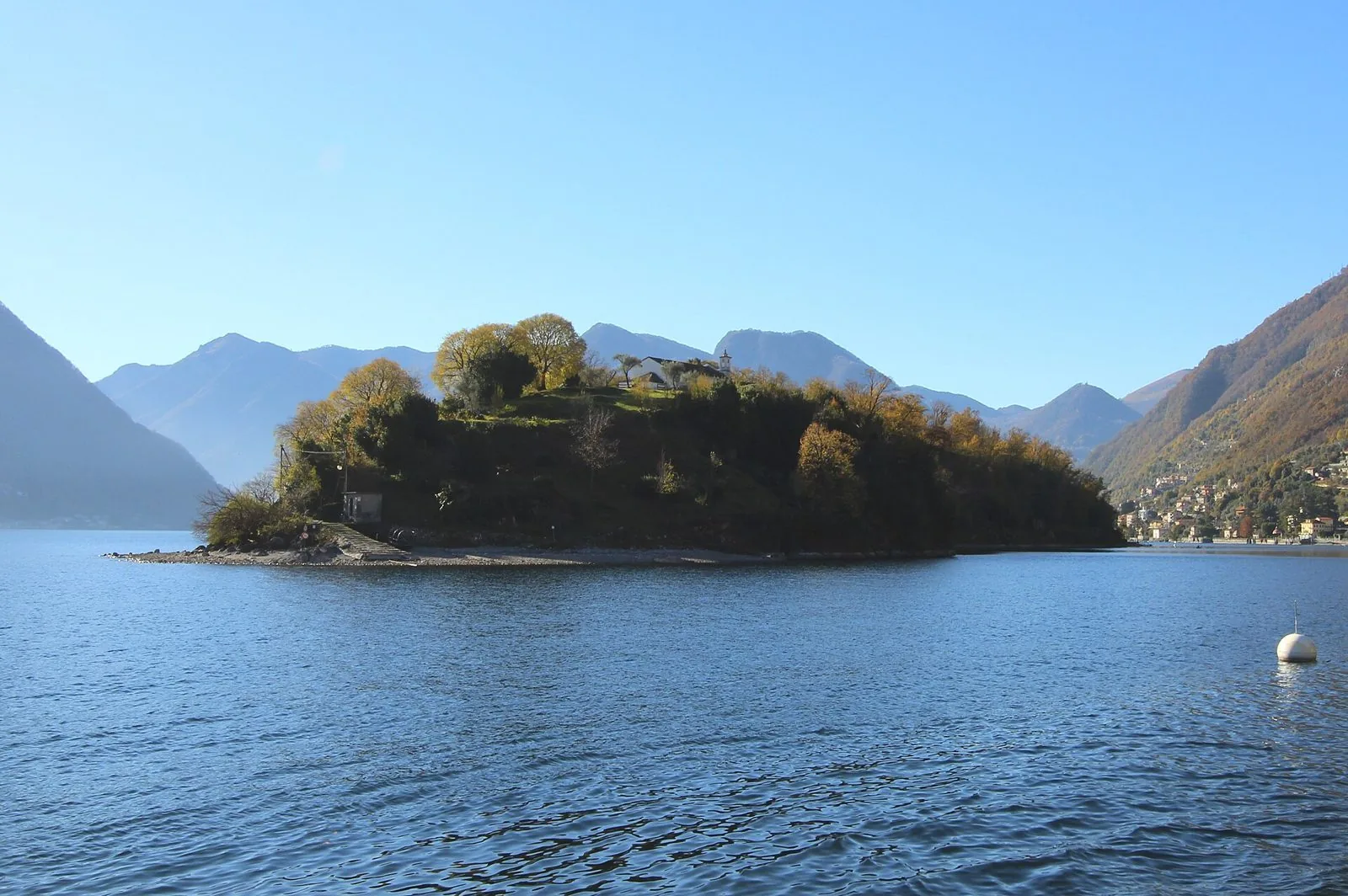L'Isola Comacina coperta di vegetazione nel Lago di Como, con le montagne sullo sfondo